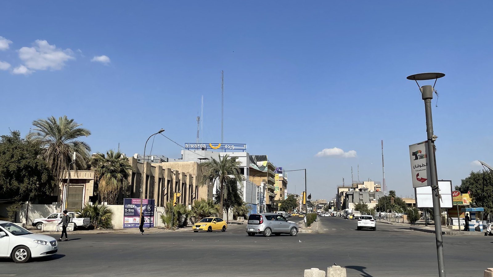 Al Warda sign installed above a storefront on a Baghdad street