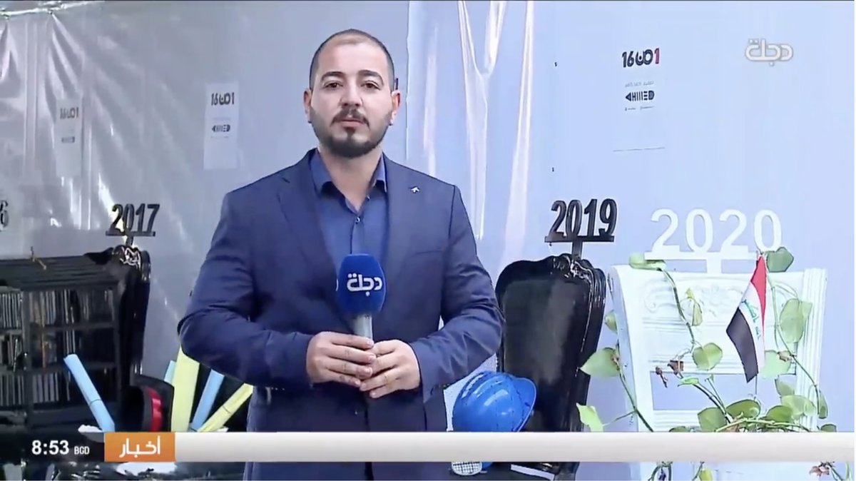 Dijlah TV reporting live from the chair exhibition, the 2017, 2019 and 2020 pieces behind him